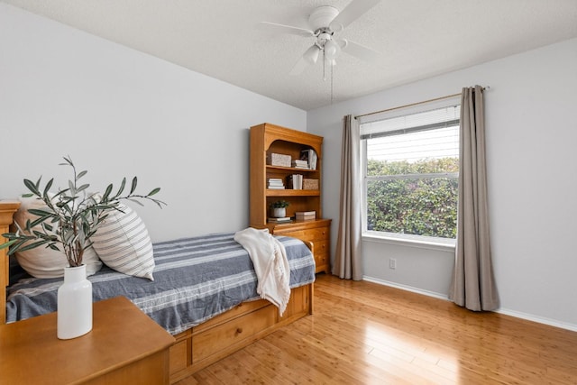 bedroom with baseboards, ceiling fan, and light wood-style floors