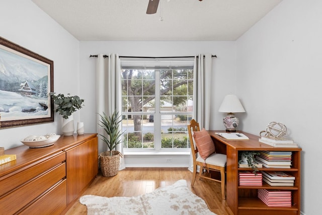 sitting room with baseboards, light wood-style flooring, and a ceiling fan