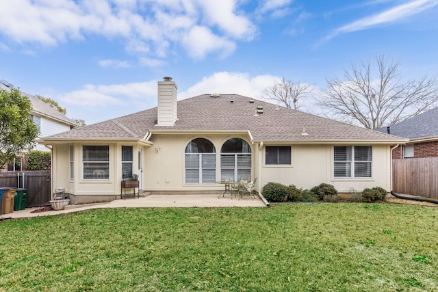 rear view of house featuring a lawn, a patio, a chimney, and fence