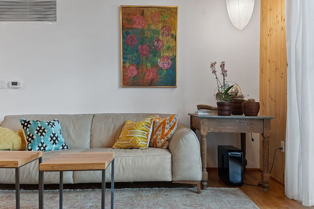 living area featuring visible vents and wood finished floors