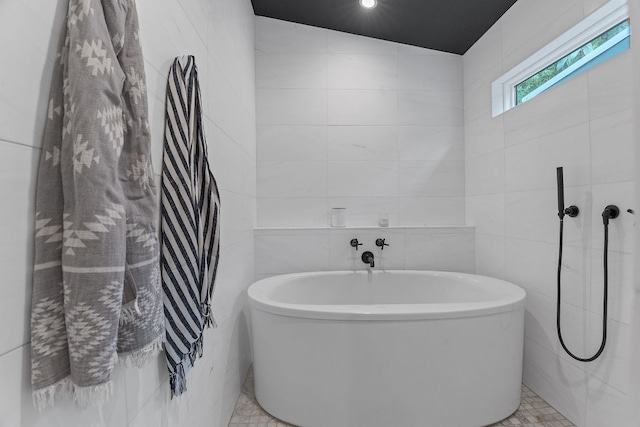 full bathroom featuring a soaking tub and tile walls