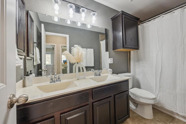 full bathroom with toilet, tile patterned flooring, double vanity, and a sink