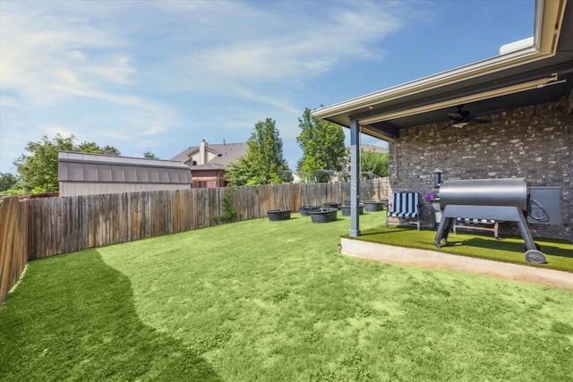 view of yard with a fenced backyard and a ceiling fan