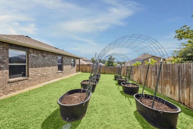 view of yard with a garden and a fenced backyard