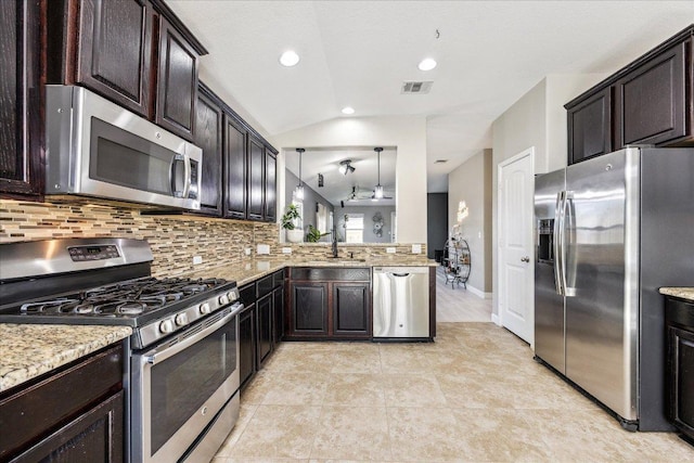 kitchen featuring lofted ceiling, stainless steel appliances, visible vents, and decorative backsplash