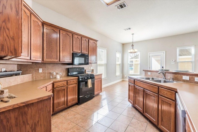 kitchen featuring light tile patterned floors, tasteful backsplash, visible vents, a sink, and black appliances