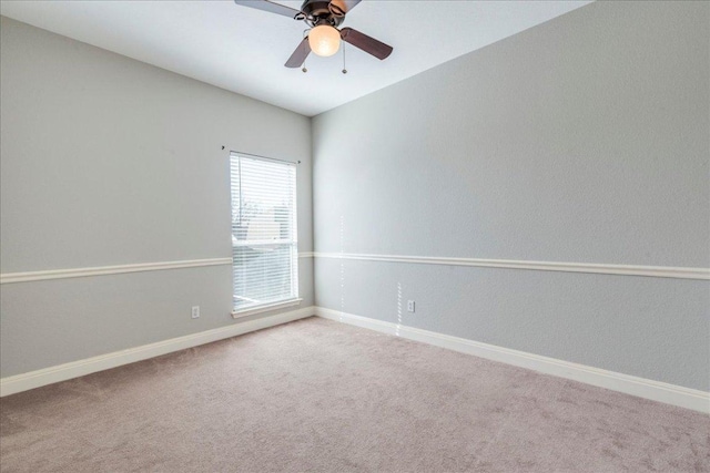 carpeted empty room featuring ceiling fan and baseboards