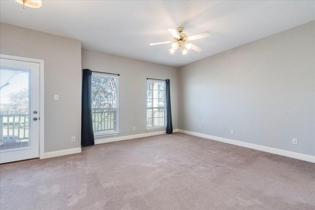 spare room featuring ceiling fan, carpet, and baseboards