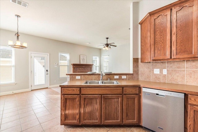 kitchen with a peninsula, a sink, visible vents, brown cabinets, and dishwasher