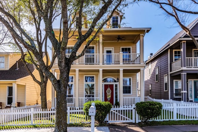 view of front of house featuring a porch, a balcony, a fenced front yard, and a ceiling fan