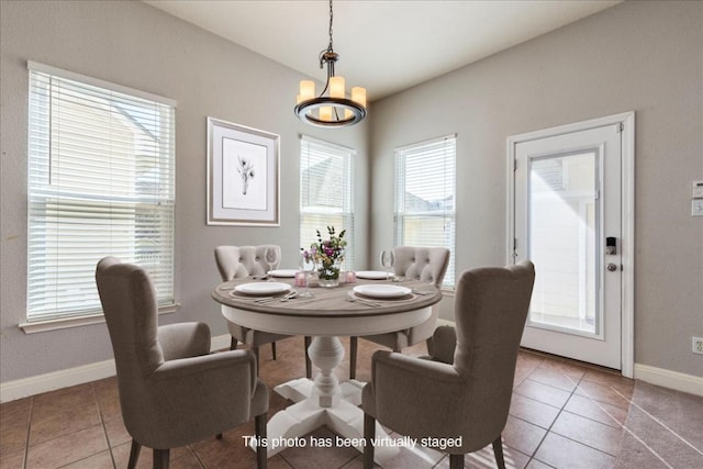 dining area with tile patterned flooring, baseboards, and a chandelier