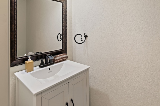 bathroom with a textured wall and vanity