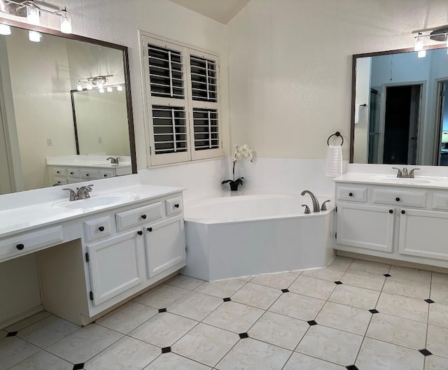 full bathroom with a garden tub, tile patterned flooring, two vanities, and a sink