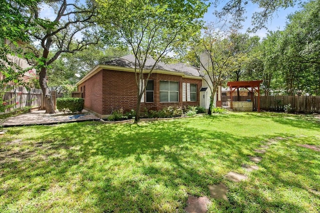 view of side of property featuring a fenced backyard, a lawn, and brick siding