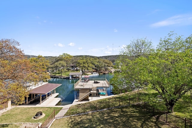 view of dock featuring a fire pit, a patio area, fence private yard, and a water view