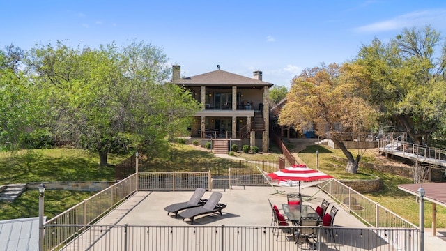 view of community featuring stairway, a patio area, and fence