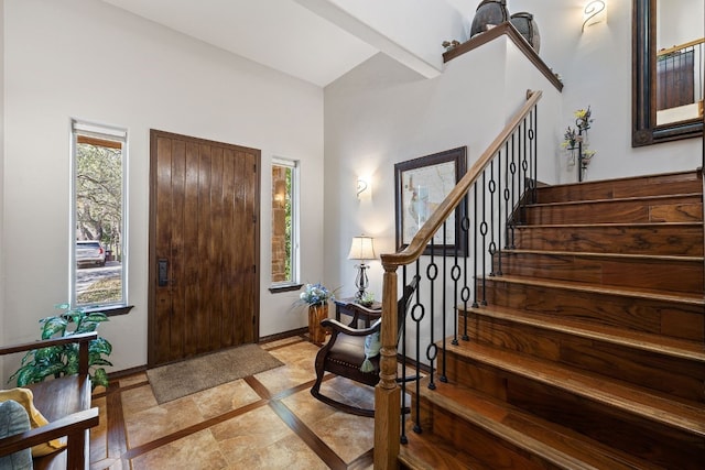 entrance foyer featuring stairs and baseboards