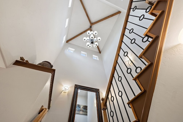 staircase featuring a towering ceiling and a notable chandelier