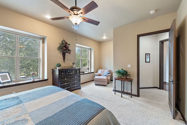 bedroom featuring ceiling fan, baseboards, and light colored carpet