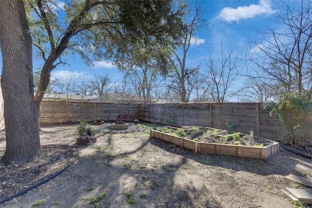 view of yard featuring a fenced backyard and a garden