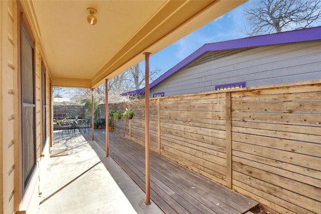 wooden terrace with a patio area and a fenced backyard