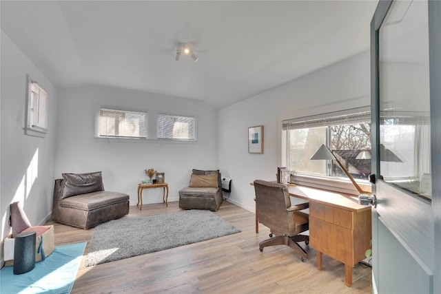 office with baseboards, vaulted ceiling, and light wood finished floors