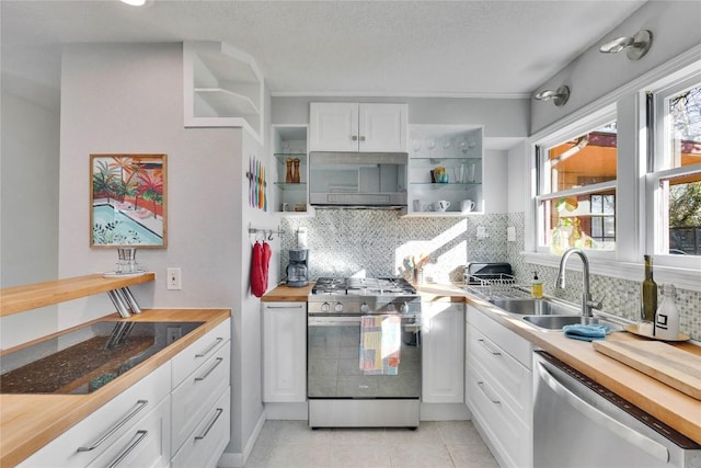 kitchen with stainless steel appliances, butcher block countertops, a sink, white cabinetry, and open shelves