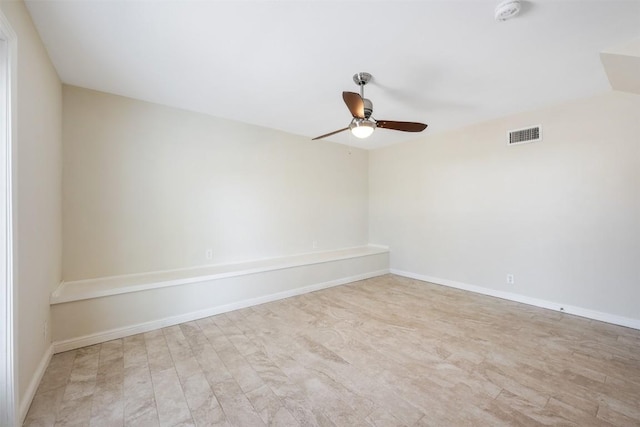 empty room featuring visible vents, ceiling fan, baseboards, and wood finished floors