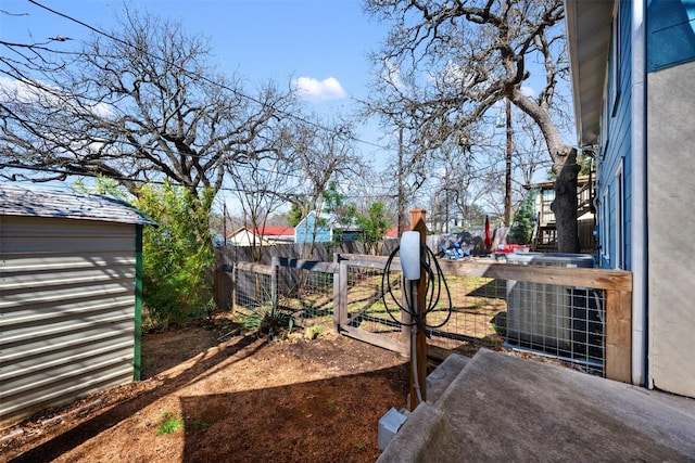 view of yard with fence private yard, an outdoor structure, and central AC unit