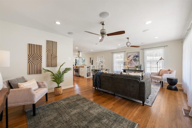 living room featuring recessed lighting, wood finished floors, and baseboards