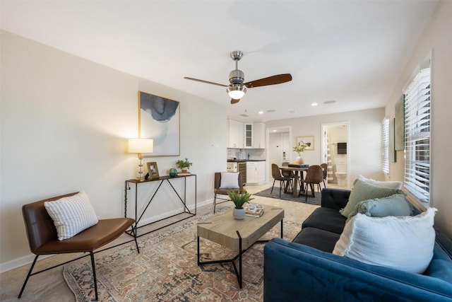 living area featuring recessed lighting, a ceiling fan, and baseboards