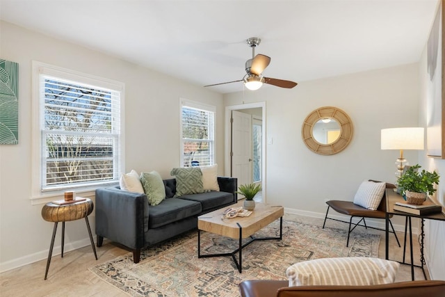 living room with ceiling fan and baseboards