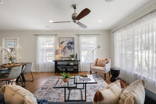 living room featuring a ceiling fan, baseboards, wood finished floors, and recessed lighting