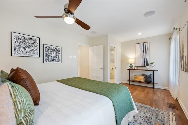 bedroom featuring a ceiling fan, baseboards, visible vents, and wood finished floors