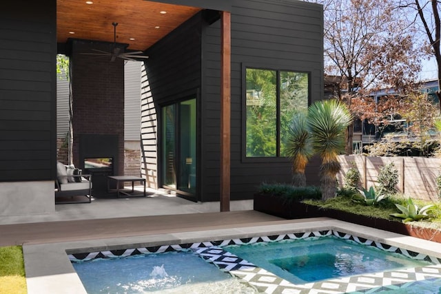 view of swimming pool with a ceiling fan, a patio area, and an in ground hot tub