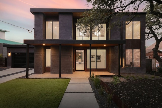 contemporary home with brick siding and a front yard