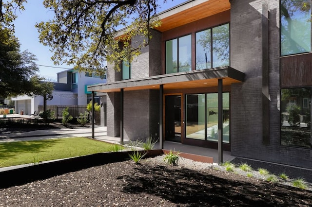 back of property featuring brick siding