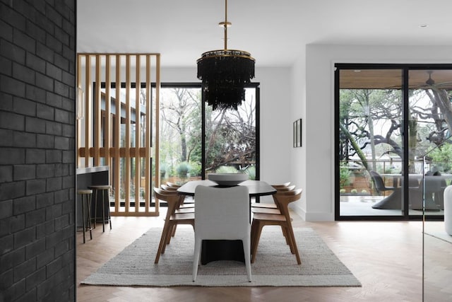 dining area with baseboards, an inviting chandelier, and wood finished floors