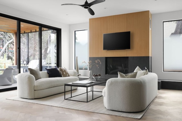 living room featuring a large fireplace and ceiling fan