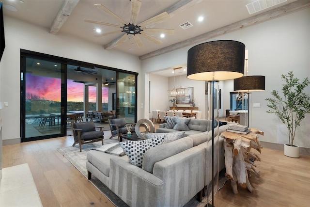 living room featuring visible vents, beamed ceiling, and wood finished floors