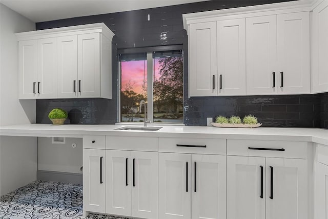 kitchen with backsplash, white cabinets, and light countertops