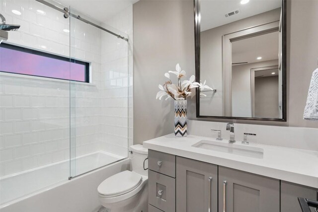 bathroom featuring vanity, toilet, visible vents, and combined bath / shower with glass door