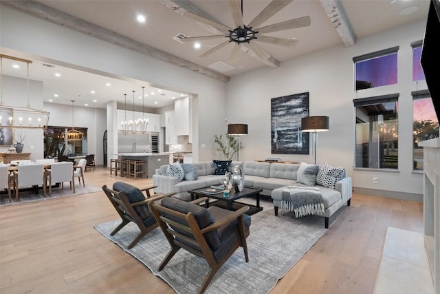 living area featuring a high ceiling, recessed lighting, visible vents, and light wood-type flooring