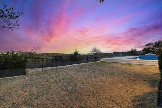 yard at dusk featuring fence