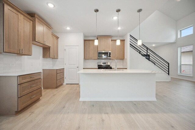 13224 Ditka Dr, Austin, TX 78652 - kitchen with appliances with stainless steel finishes, a sink, light wood finished floors, decorative backsplash, and light countertops