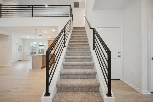 13224 Ditka Dr, Austin, TX 78652 - stairs featuring wood finished floors, baseboards, and recessed lighting