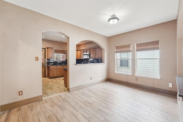 interior space featuring baseboards, plenty of natural light, and light wood-style floors