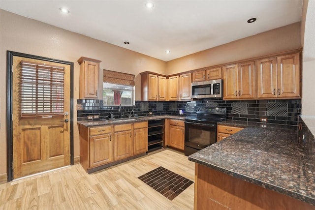 9316 Brents Elm Dr, Austin, TX 78744 - kitchen with black / electric stove, stainless steel microwave, light wood-style floors, backsplash, and dark stone counters