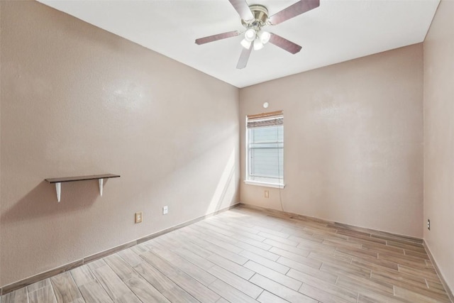 empty room featuring a ceiling fan, wood tiled floor, and baseboards