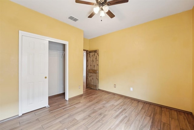 unfurnished bedroom with light wood-style floors, a ceiling fan, visible vents, and a closet